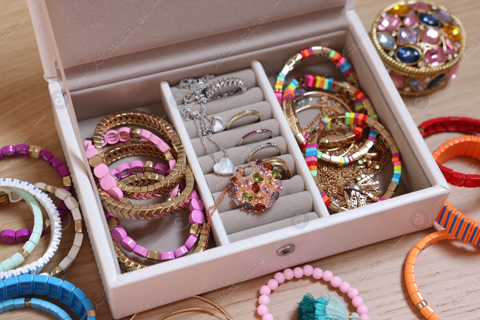 Photo of Jewelry box with stylish bracelets and other accessories on wooden table