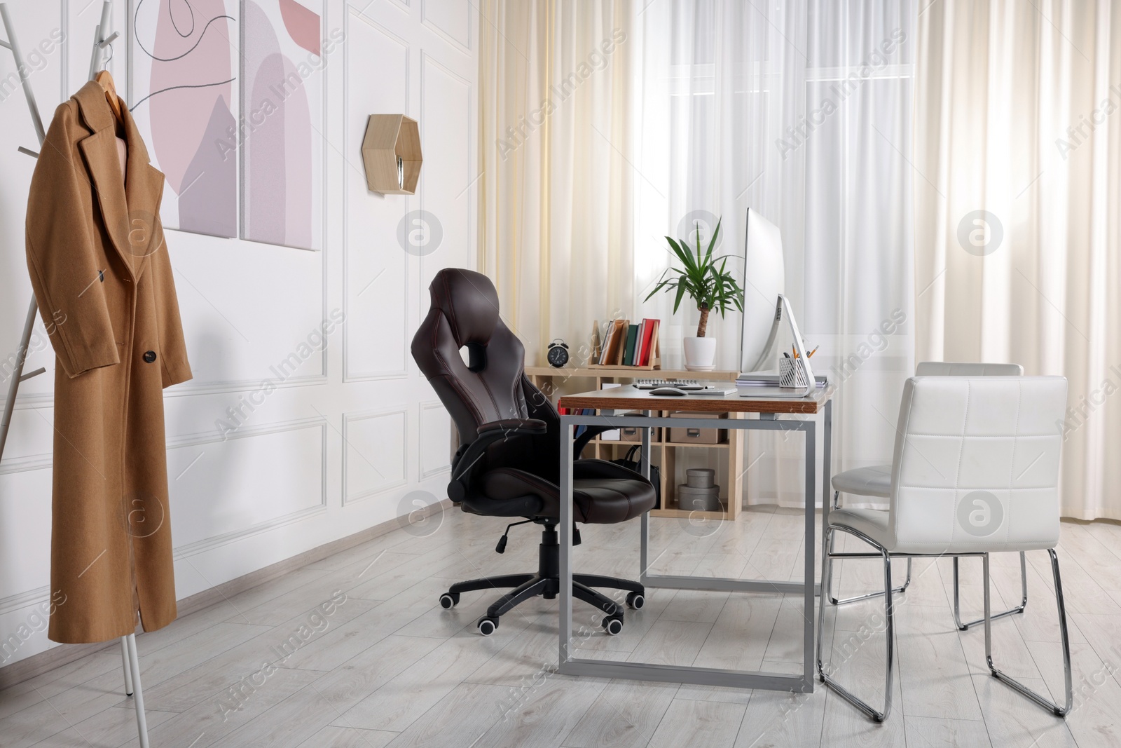 Photo of Director's workplace with wooden table, computer and comfortable armchairs. Interior design