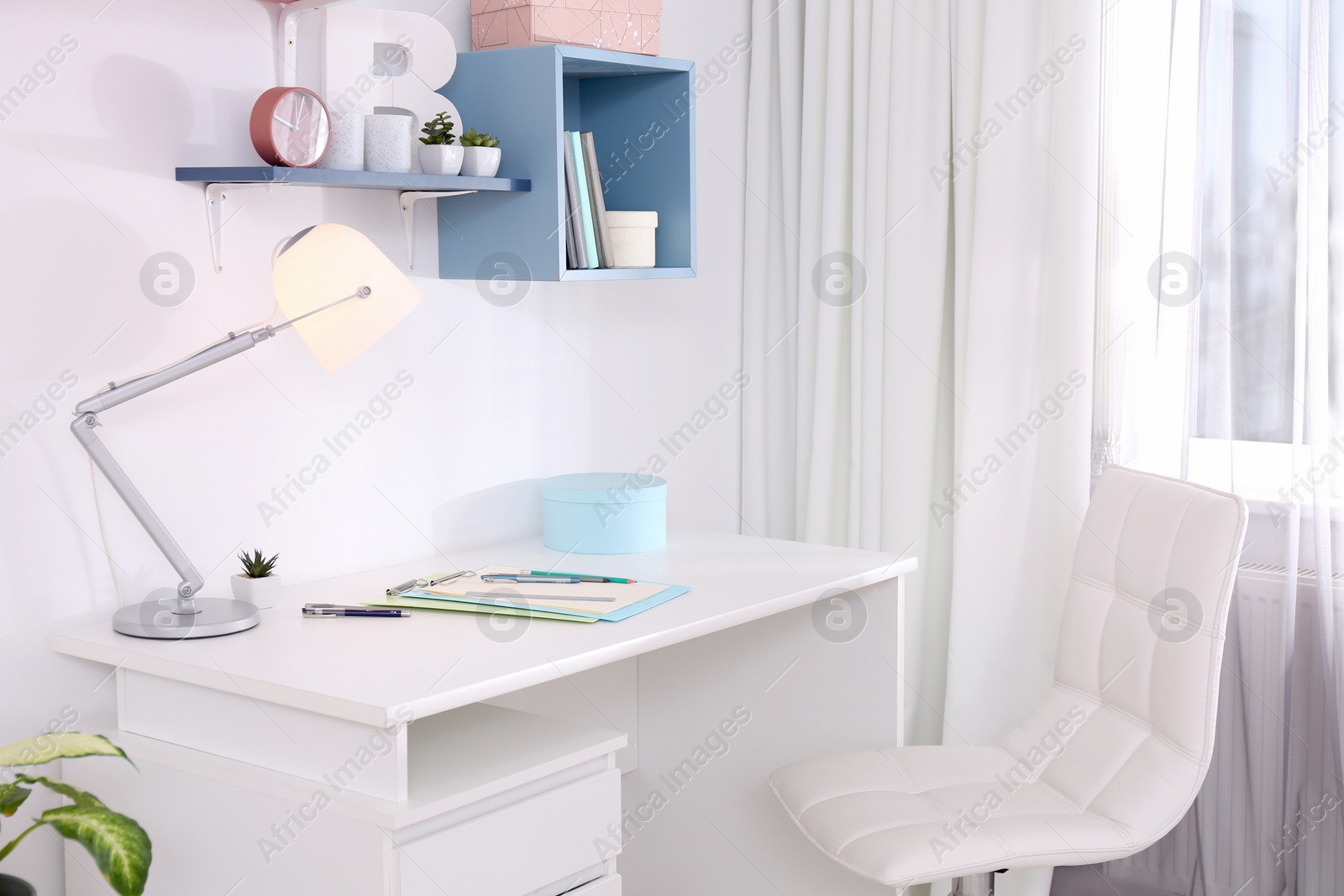 Photo of Stylish room interior with comfortable workplace near window. Design idea