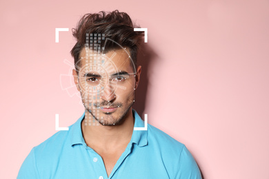 Image of Facial recognition system. Young man with scanner frame and digital biometric grid on pink background