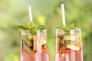 Glasses of tasty rhubarb cocktail outdoors, closeup