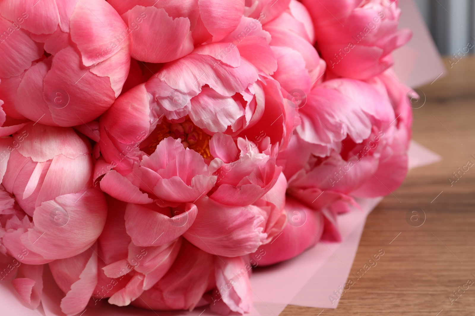 Photo of Bouquet of beautiful pink peonies on wooden table, closeup