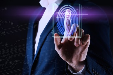 Image of Man using biometric fingerprint scanner on dark background, closeup