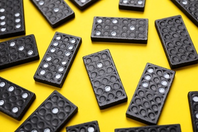 Set of black domino tiles on yellow background