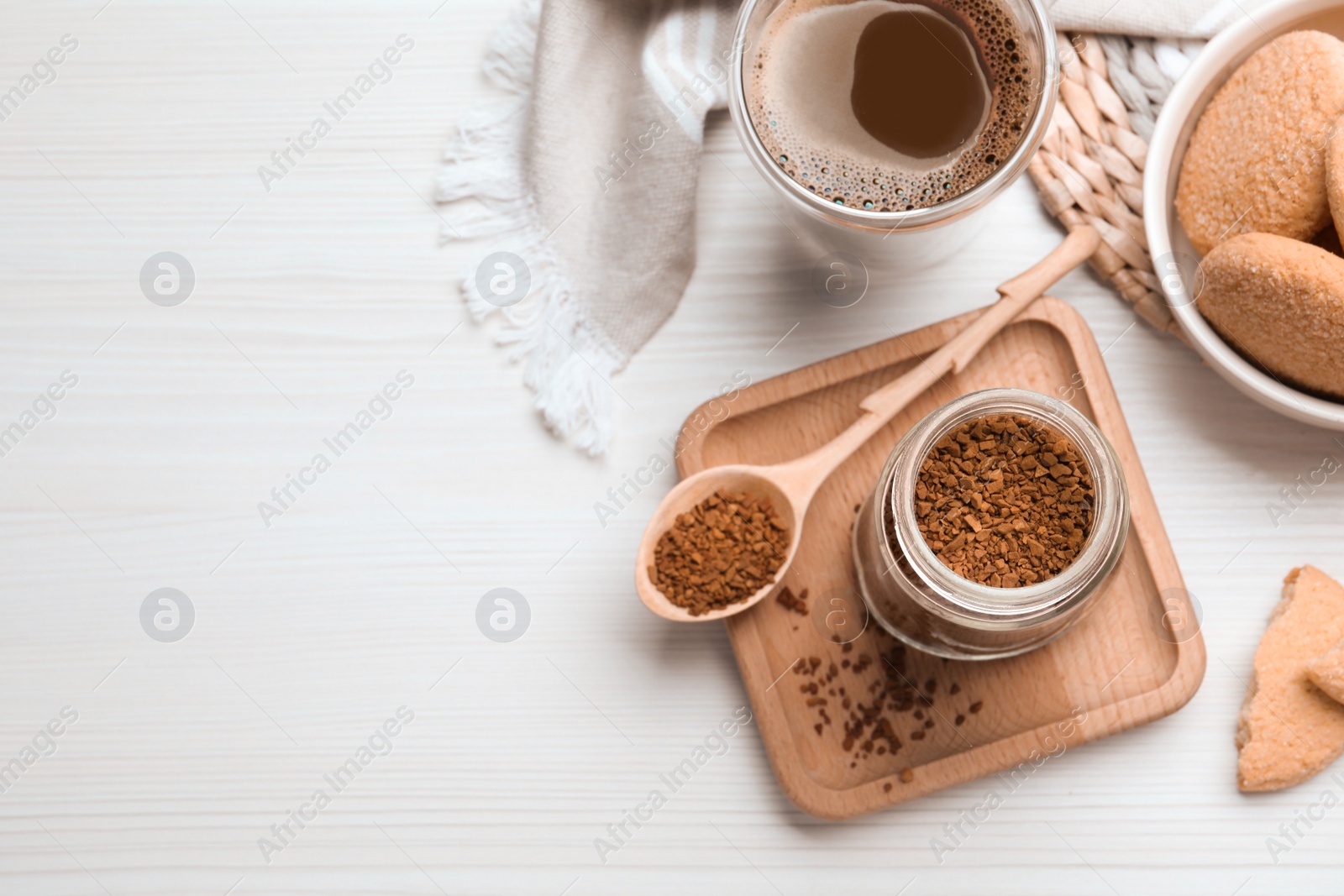Photo of Flat lay composition with instant coffee on white wooden table. Space for text