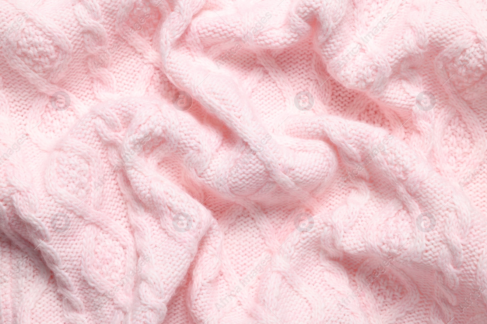 Photo of Texture of soft pink knitted fabric as background, top view