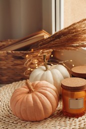 Pumpkins and scented candles on window sill