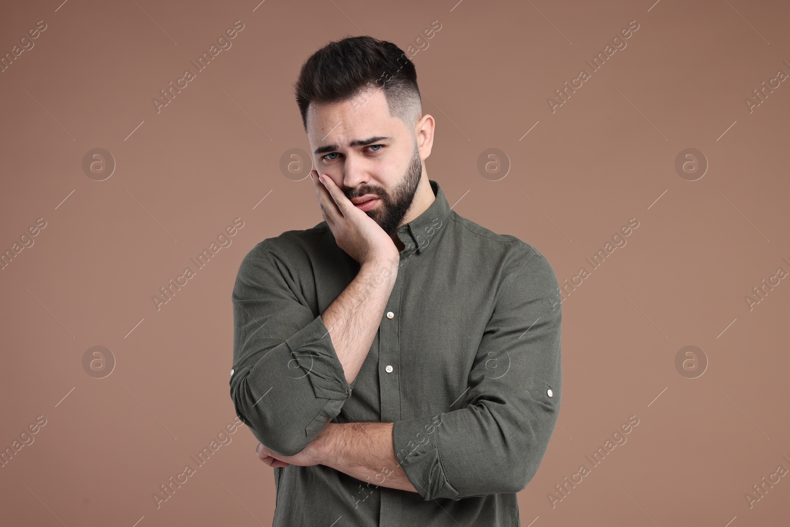 Photo of Portrait of sad man on brown background