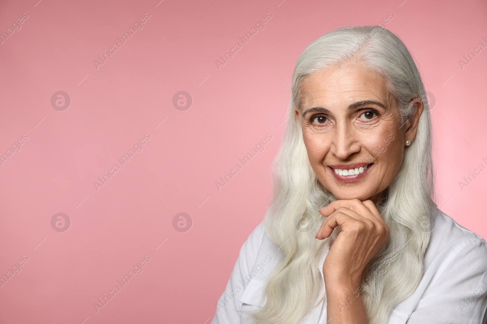 Photo of Portrait of beautiful mature woman on pink background, space for text