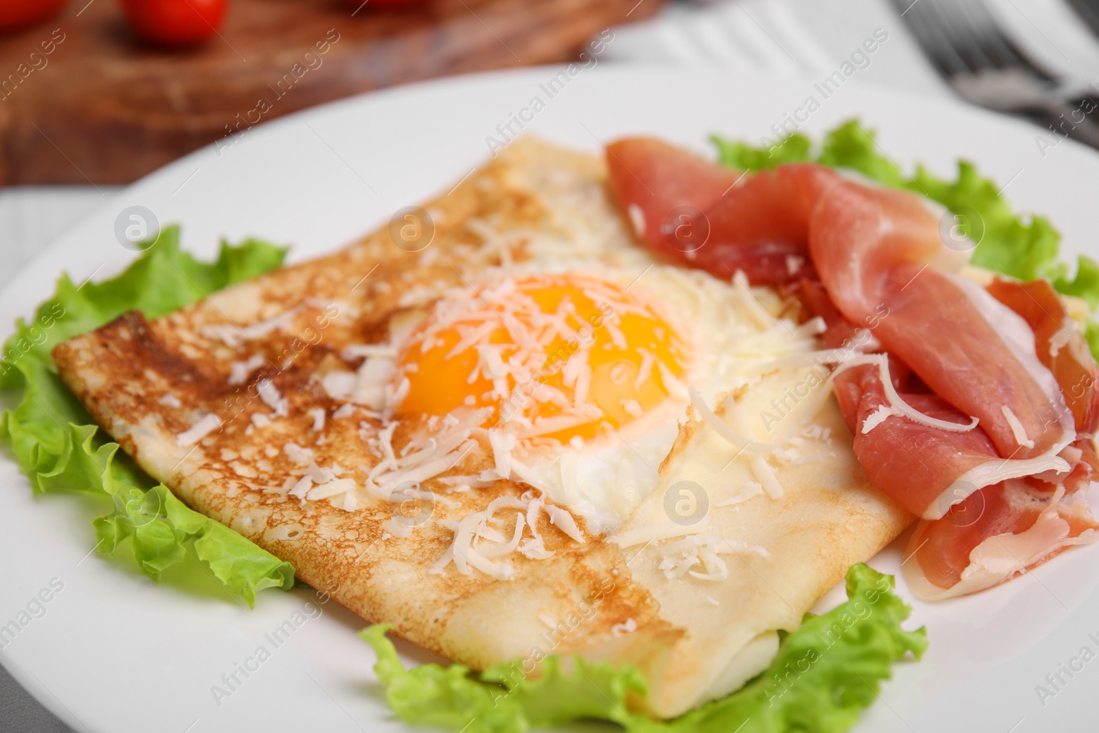 Photo of Delicious crepe with egg on plate, closeup. Breton galette