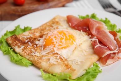 Delicious crepe with egg on plate, closeup. Breton galette