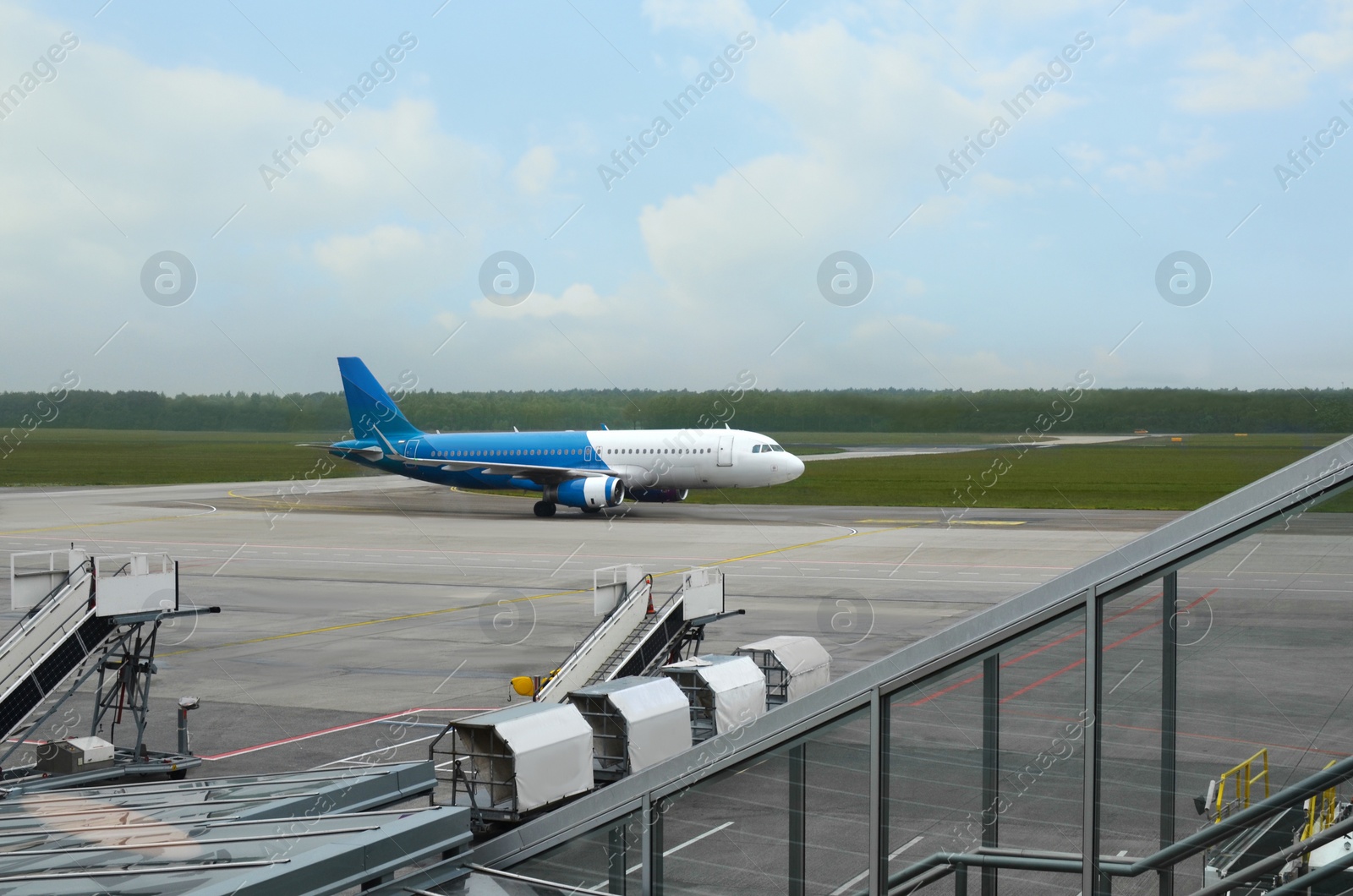 Photo of Modern airplane with pushback tractor on ramp in airport