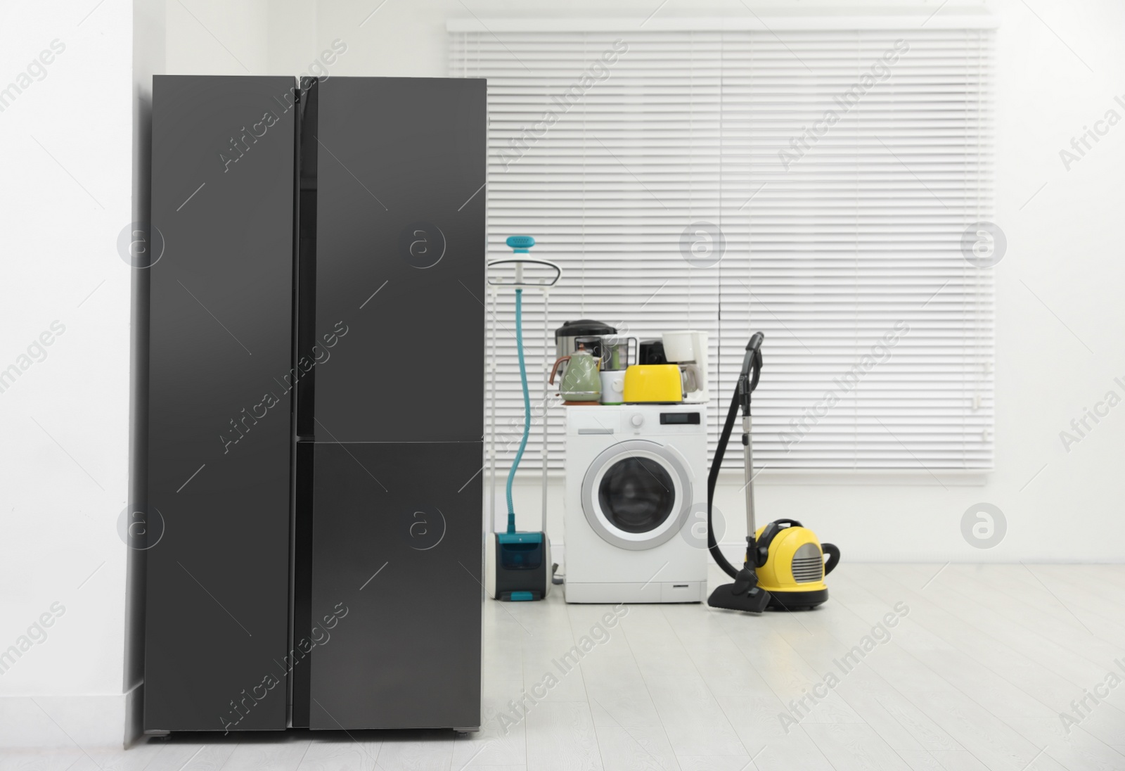Photo of Refrigerator and different household appliances in room