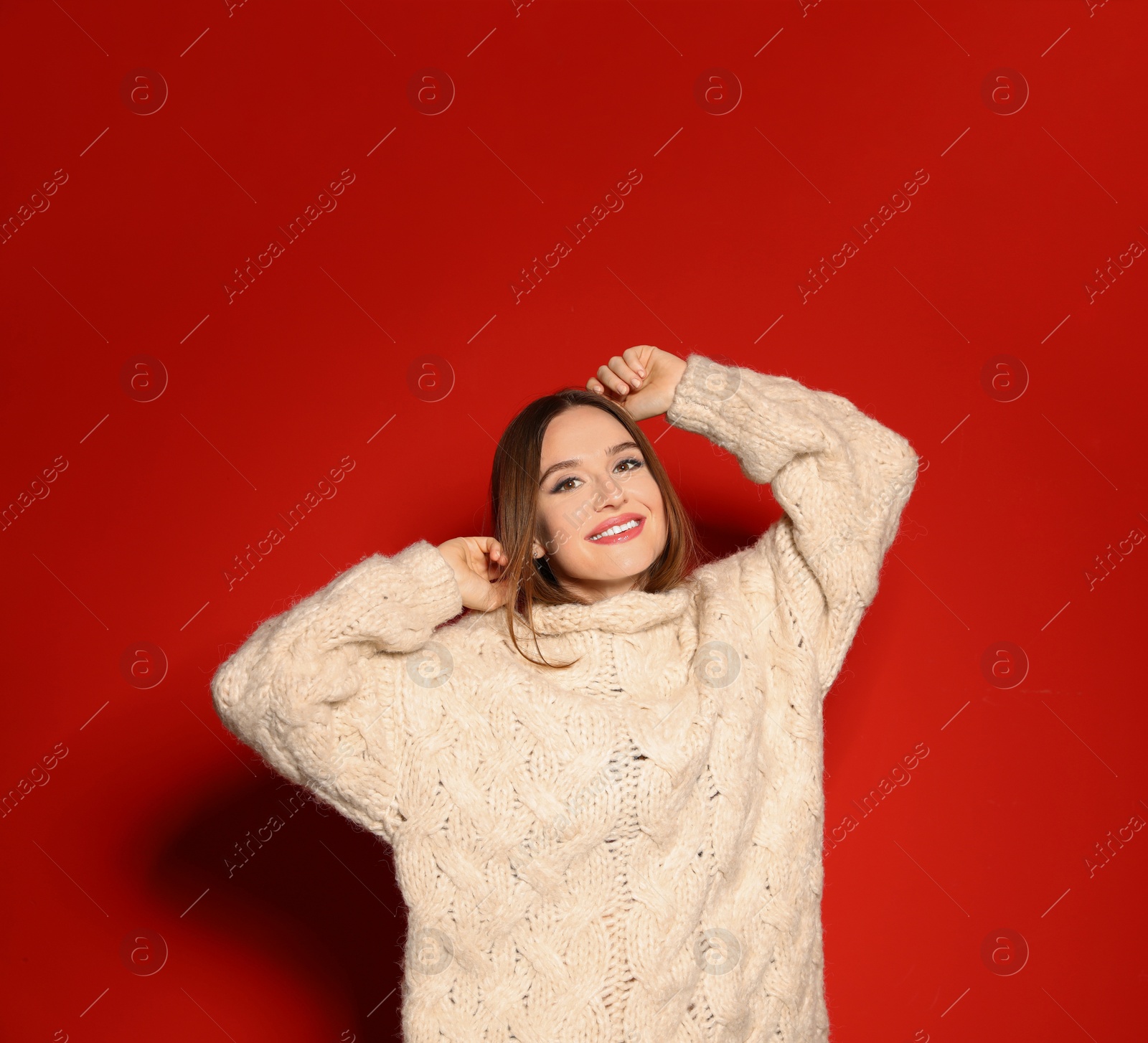 Photo of Young woman wearing Christmas sweater on red background