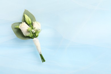 Wedding stuff. Stylish boutonniere and veil on light blue background, top view. Space for text