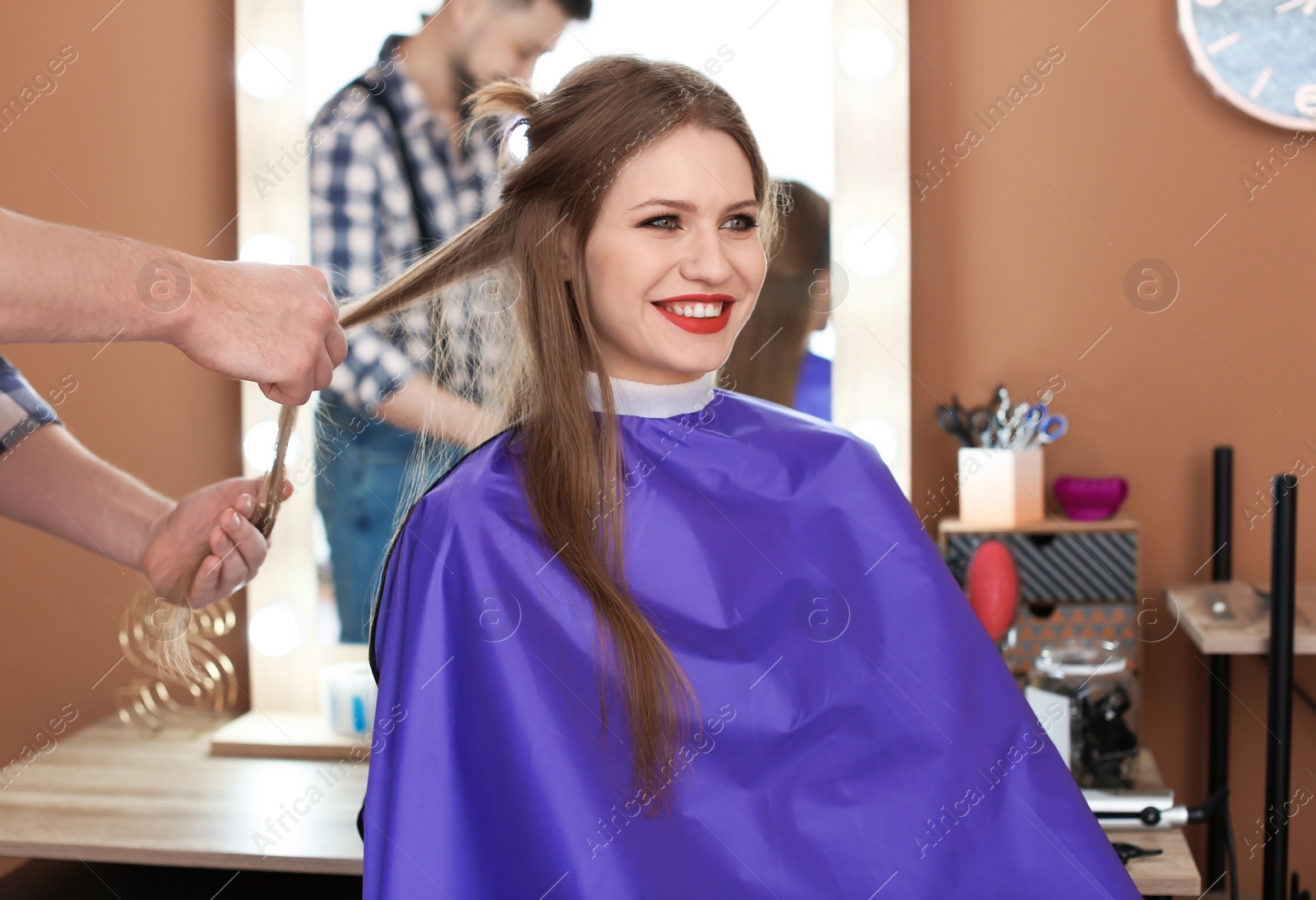 Photo of Professional hairdresser working with client in beauty salon