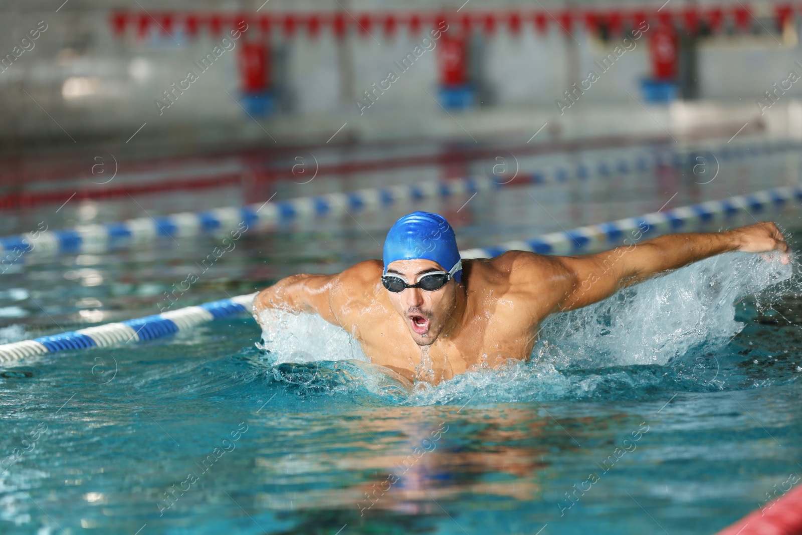 Photo of Young athletic man swimming in pool indoors