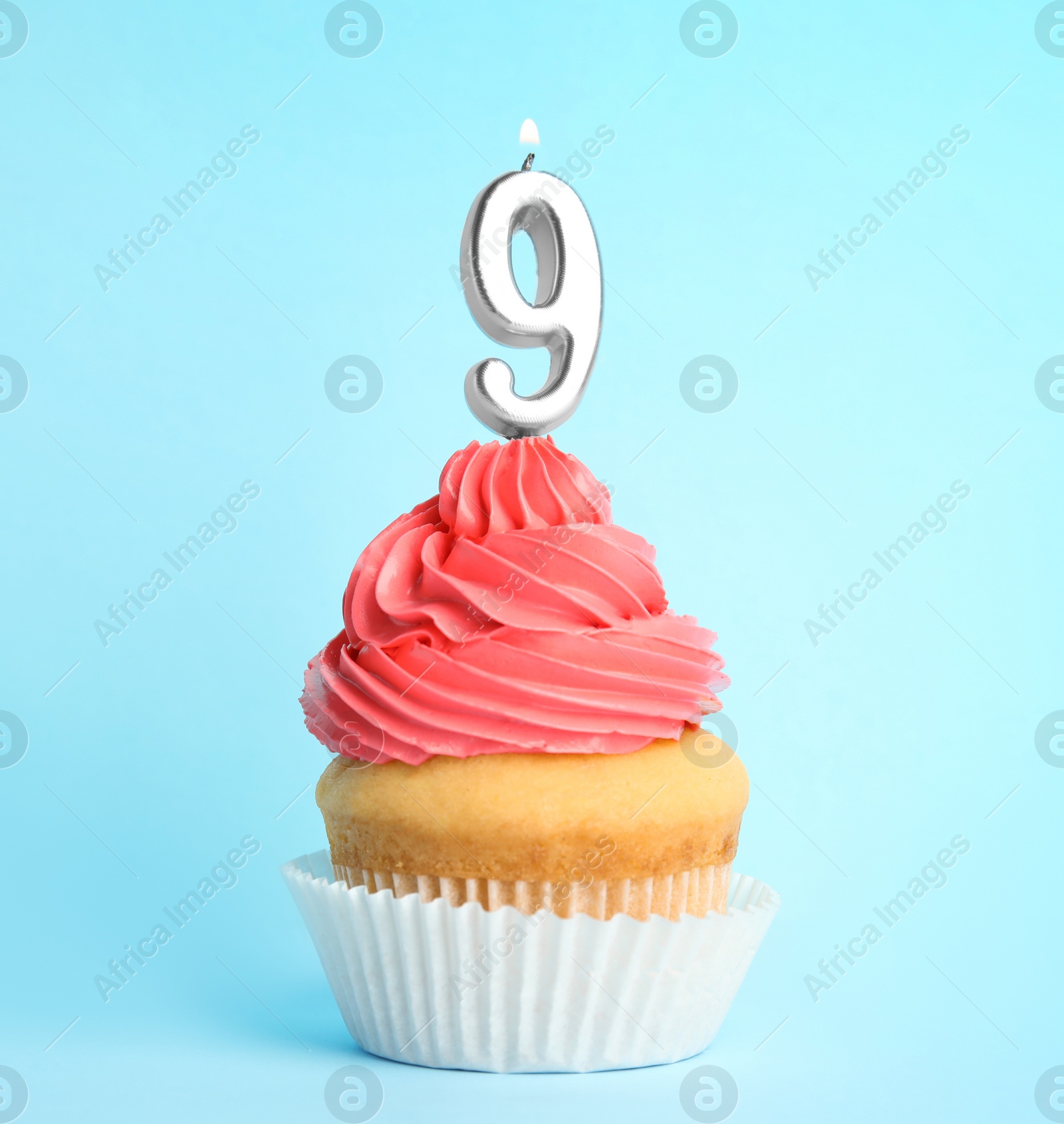 Photo of Birthday cupcake with number nine candle on blue background