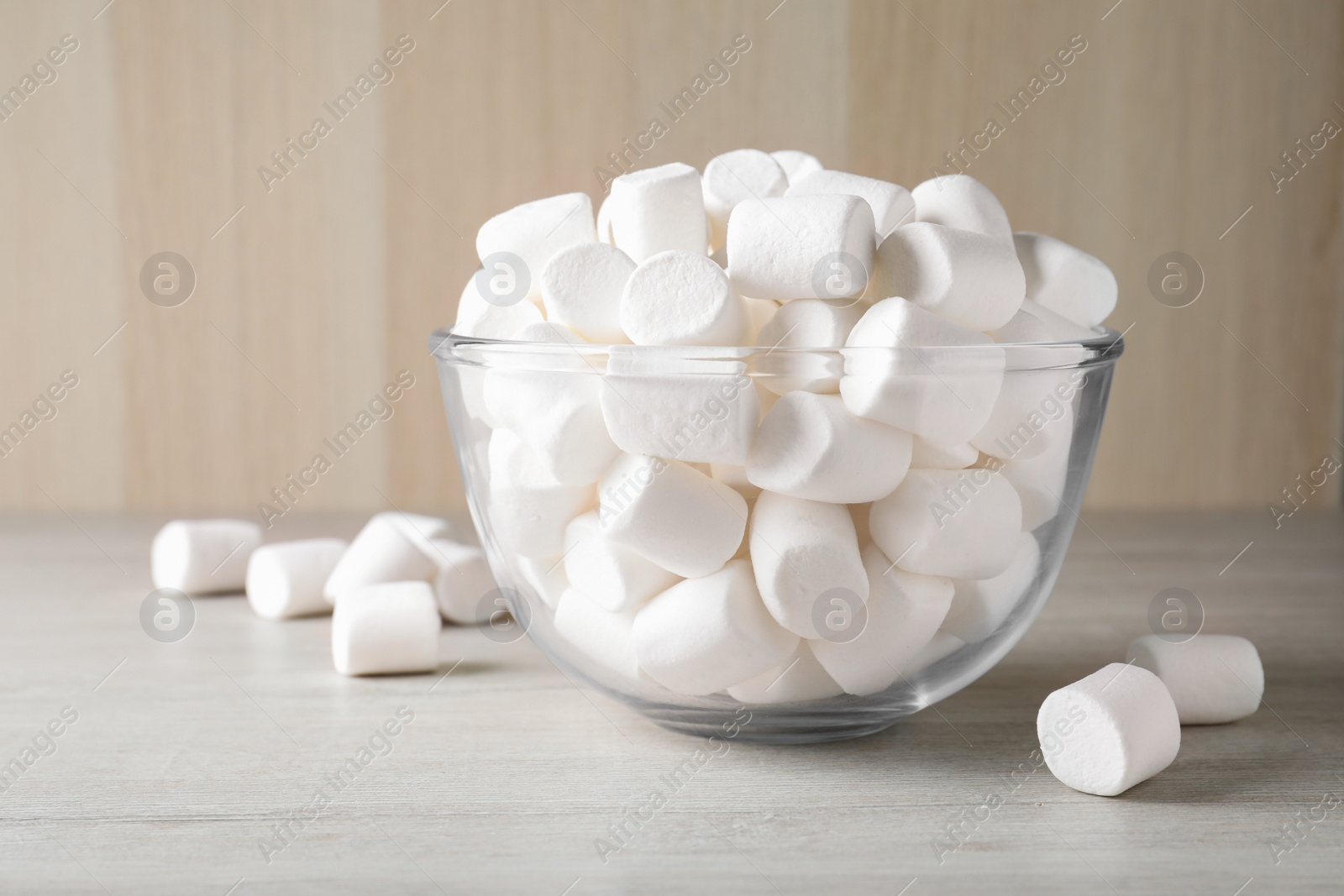 Photo of Delicious puffy marshmallows in bowl on wooden table