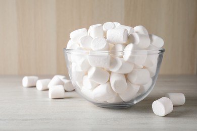 Photo of Delicious puffy marshmallows in bowl on wooden table