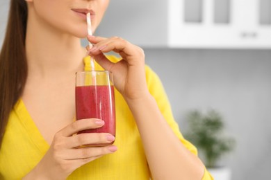 Photo of Woman drinking delicious smoothie in kitchen, closeup. Space for text
