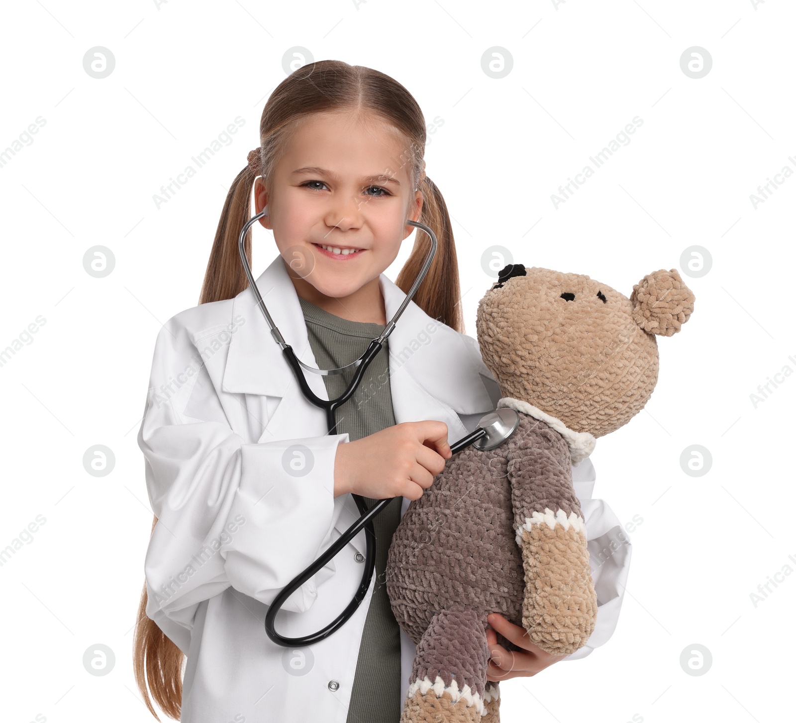 Photo of Little girl playing doctor with toy bear on white background