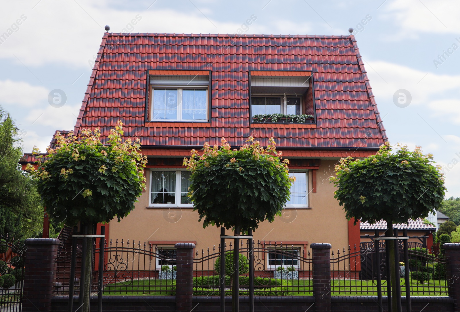 Photo of Beautiful house with brown roof against blue sky