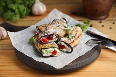 Delicious baked eggplant rolls served on wooden table