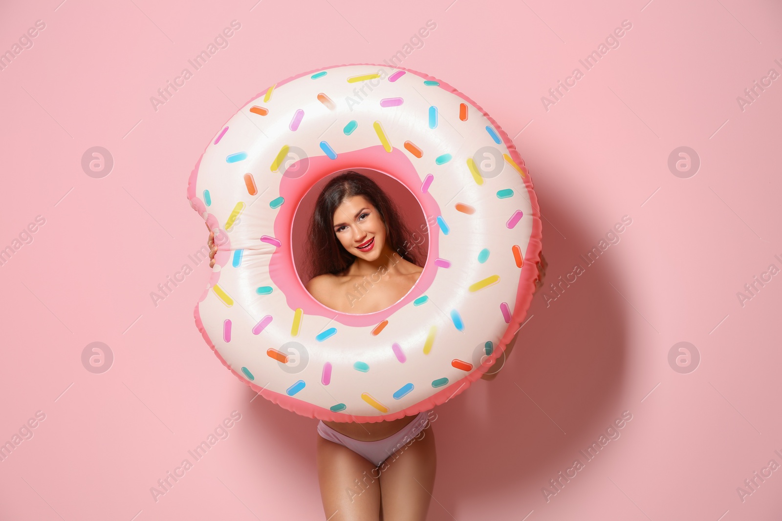 Photo of Beautiful young woman with inflatable ring on color background