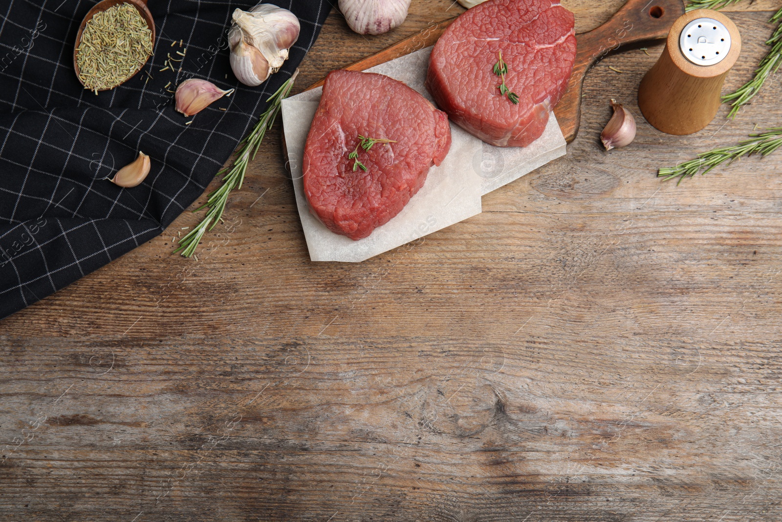 Photo of Flat lay composition with fresh beef cut on wooden table. Space for text