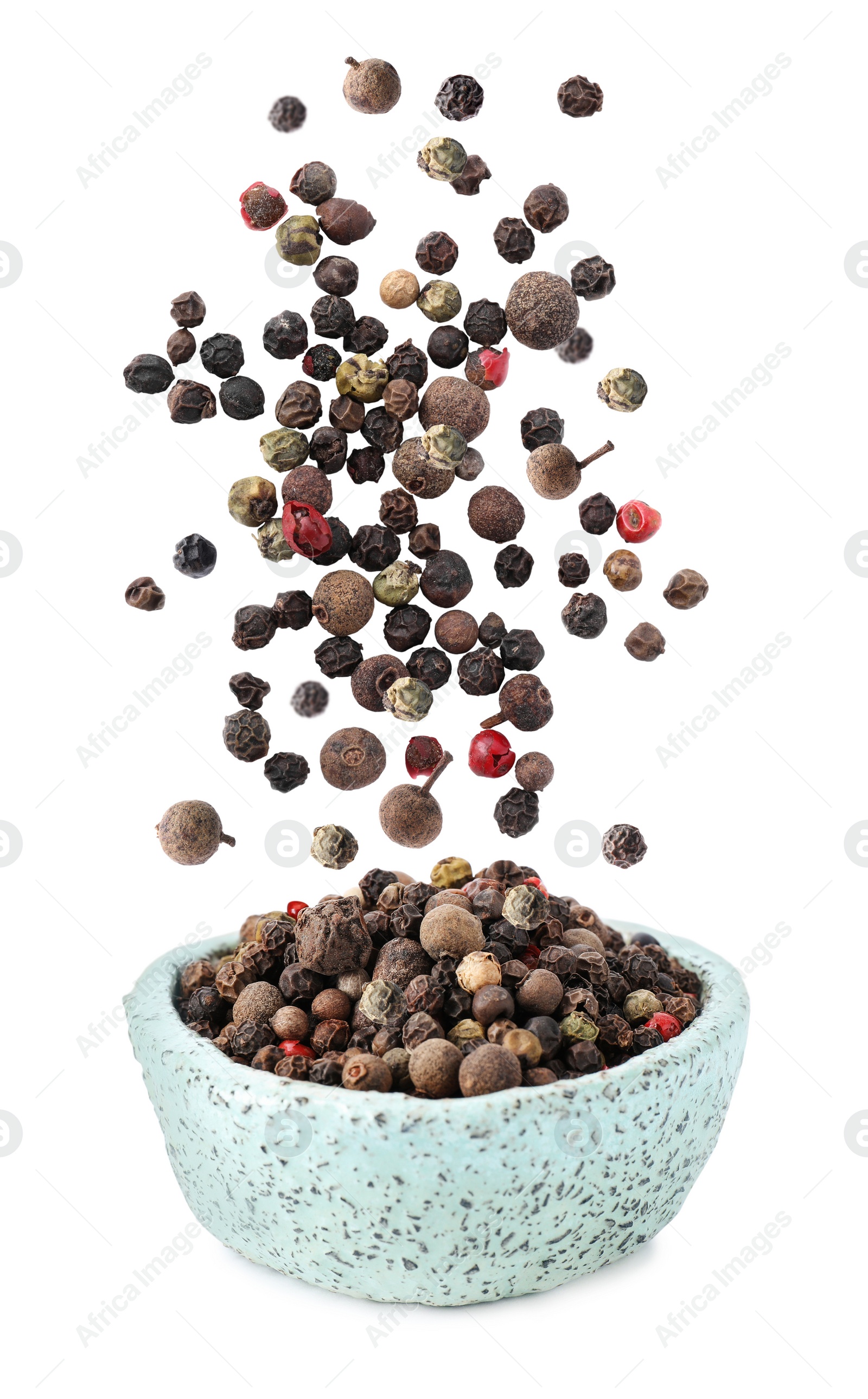 Image of Different peppercorns falling into bowl on white background