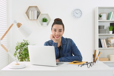 Photo of Home workplace. Portrait of happy woman near laptop at white desk in room