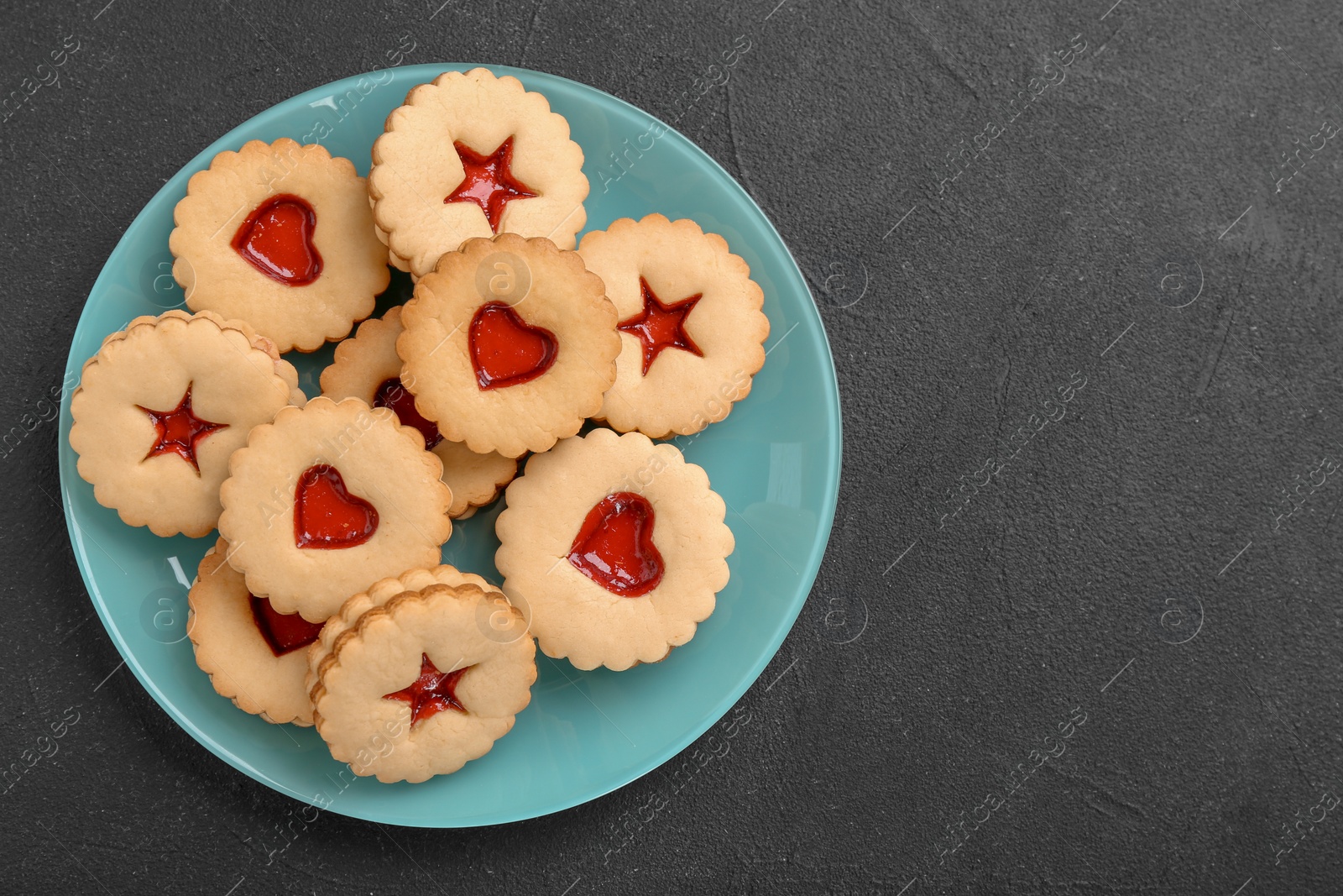 Photo of Traditional Christmas Linzer cookies with sweet jam on plate, top view