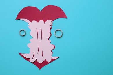Photo of Divorce concept. Paper cutout of apple core and rings on light blue background, flat lay with space for text
