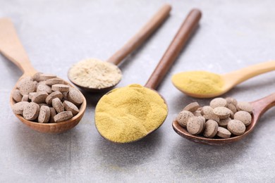 Different types of brewer's yeast on grey table, closeup