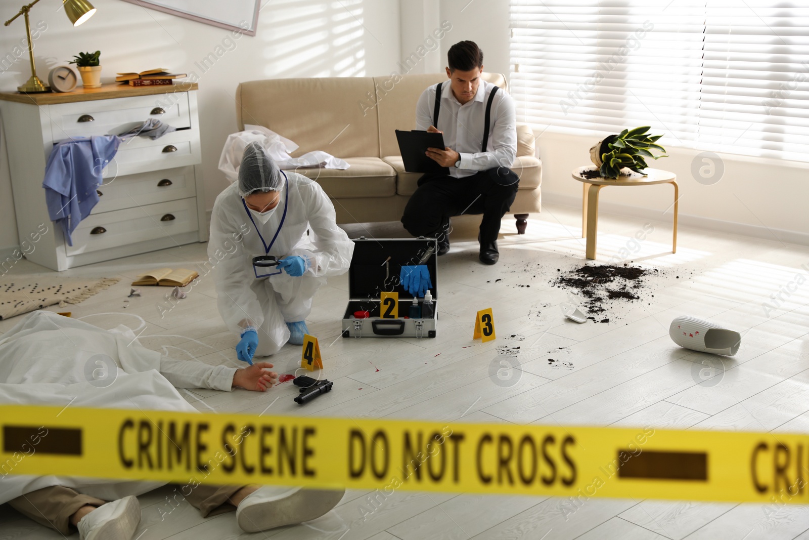 Photo of Investigators working at crime scene with dead body