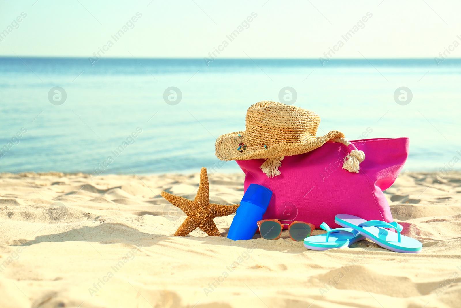 Photo of Composition with stylish beach accessories on sand near sea. Space for text