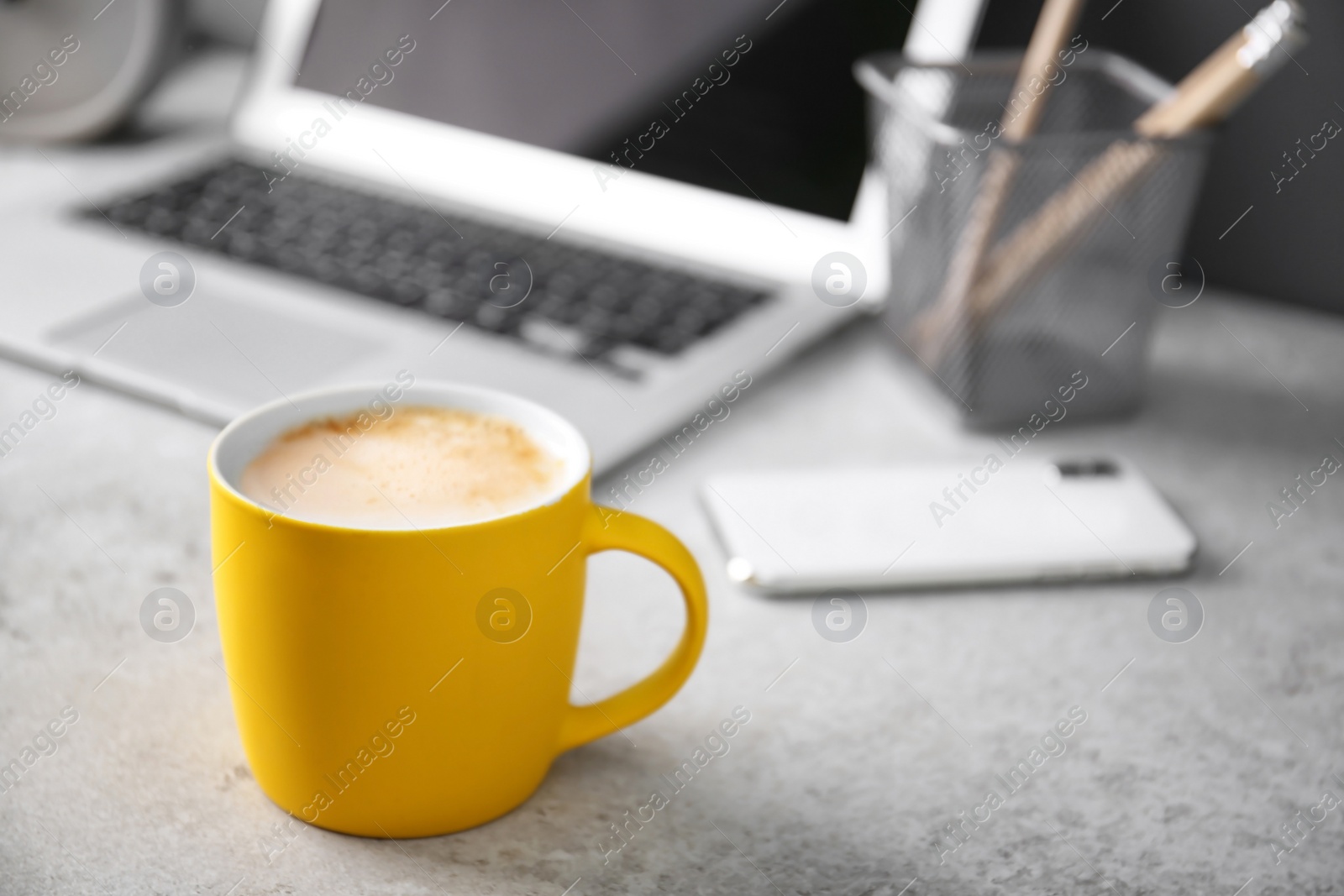 Photo of Yellow cup with coffee on office table. Space for text