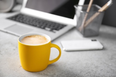 Photo of Yellow cup with coffee on office table. Space for text