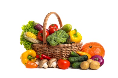 Photo of Wicker basket with fresh vegetables on white background