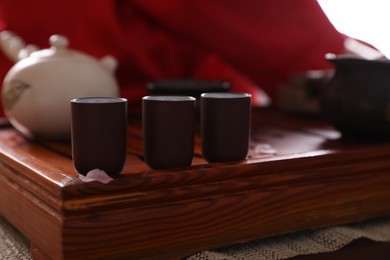 Photo of Cups for traditional tea ceremony on wooden tray