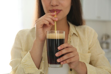 Photo of Young woman with cold kvass indoors, closeup. Traditional Russian summer drink