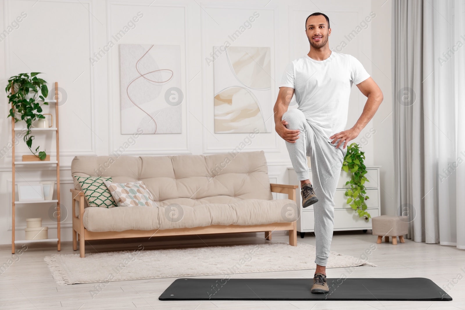 Photo of Man doing morning exercise on fitness mat at home