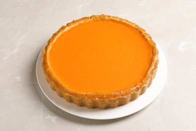 Photo of Fresh delicious homemade pumpkin pie on light background