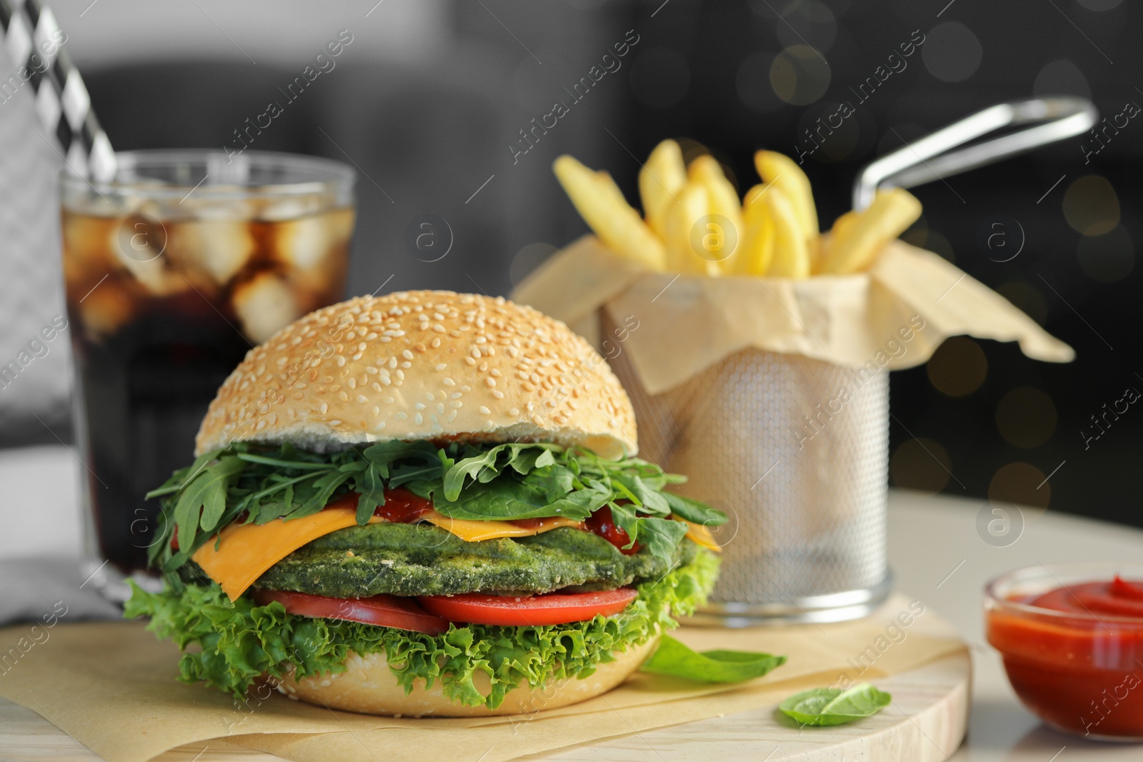 Photo of Tasty vegetarian burger served with french fries and soda drink on white table, closeup. Space for text