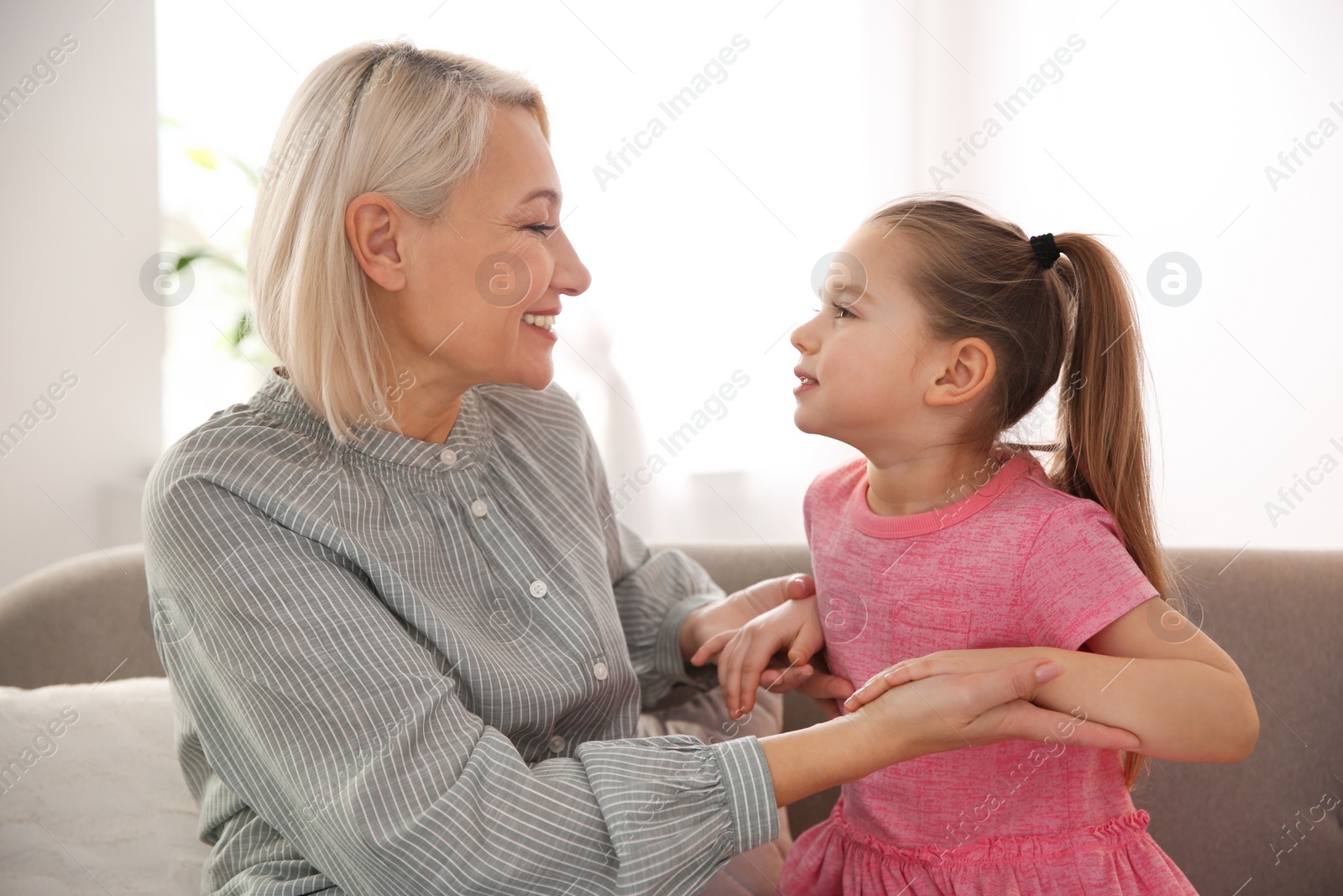 Photo of Mature woman with her little granddaughter at home