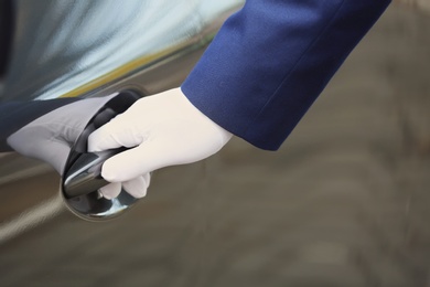 Closeup view of chauffeur opening car door