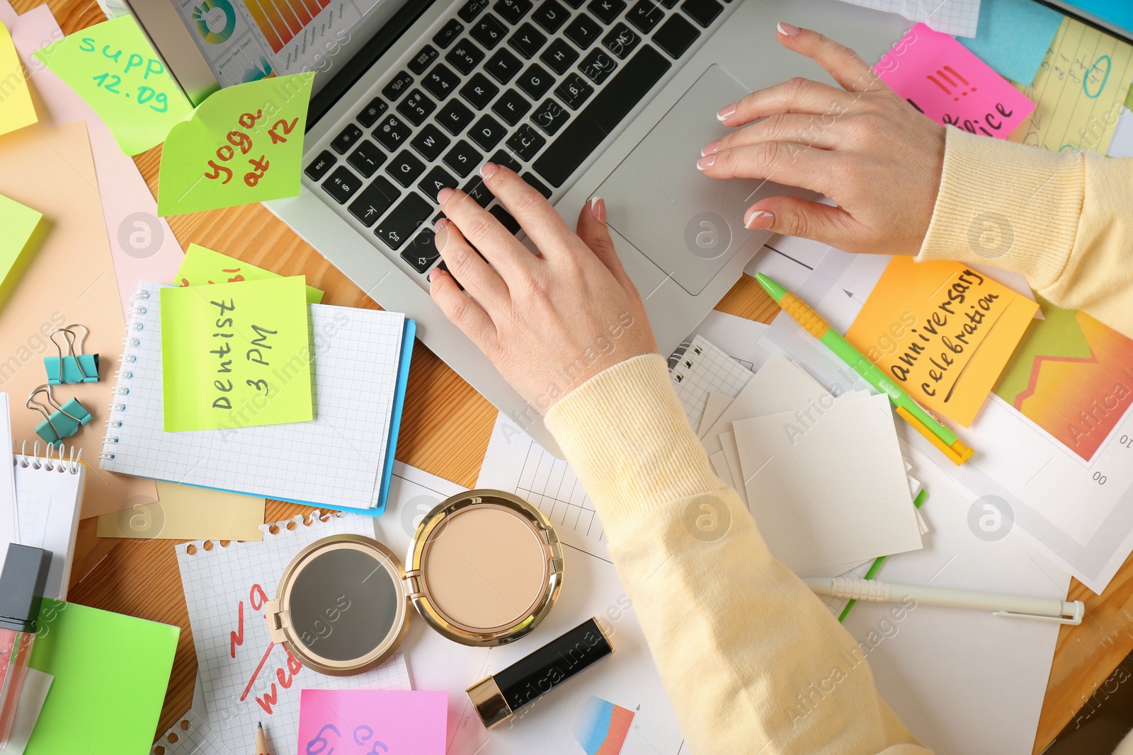 Photo of Woman using laptop at messy table, top view. Concept of being overwhelmed by work