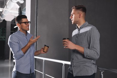 Photo of Coworkers talking during coffee break in office