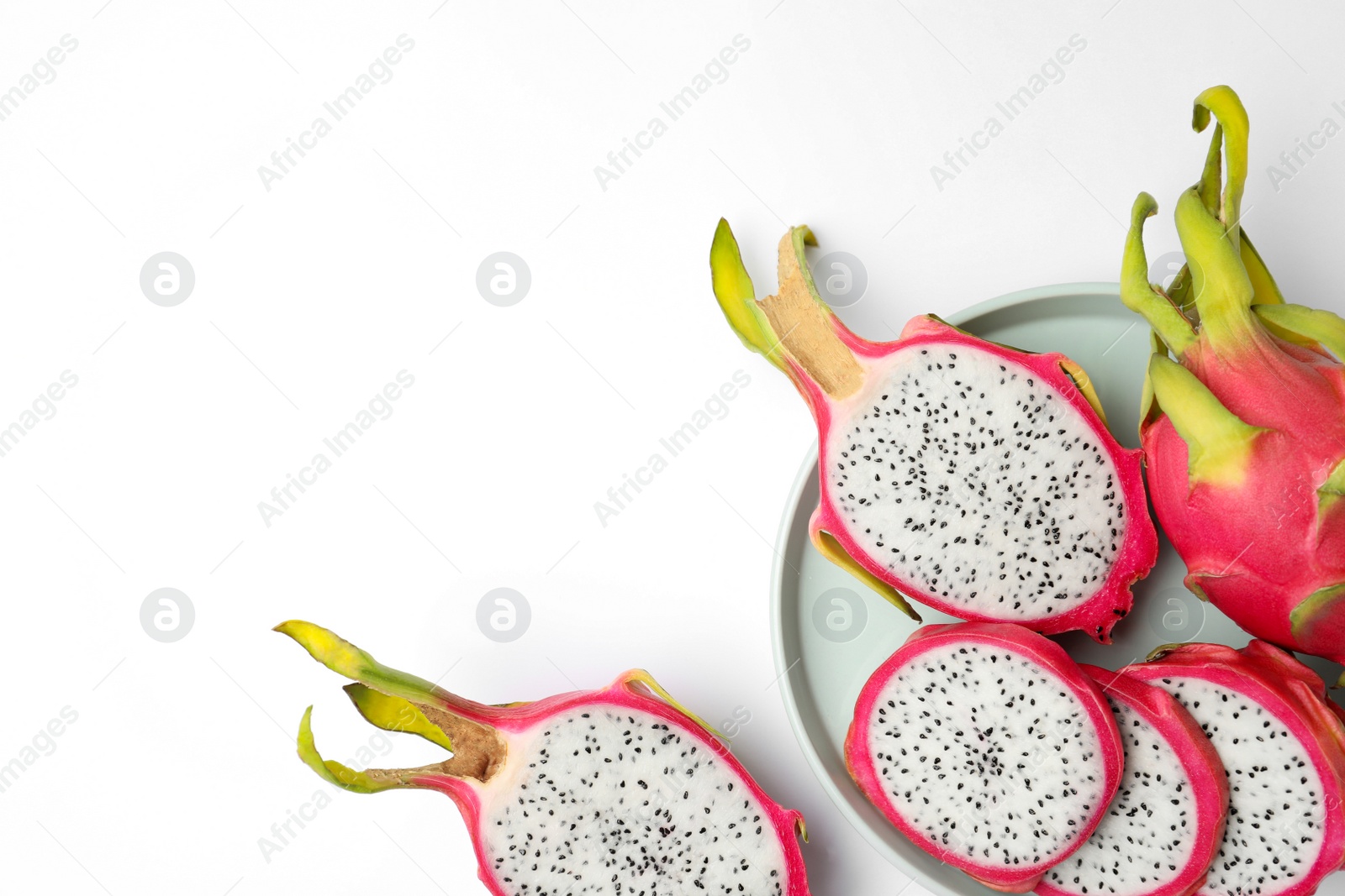 Photo of Delicious cut and whole dragon fruits (pitahaya) on white background, top view